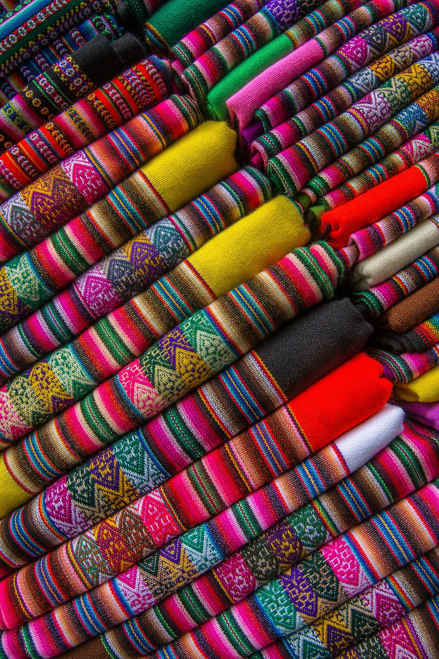 Home Colorful traditional woven fabrics displaying intricate patterns and vibrant colors.